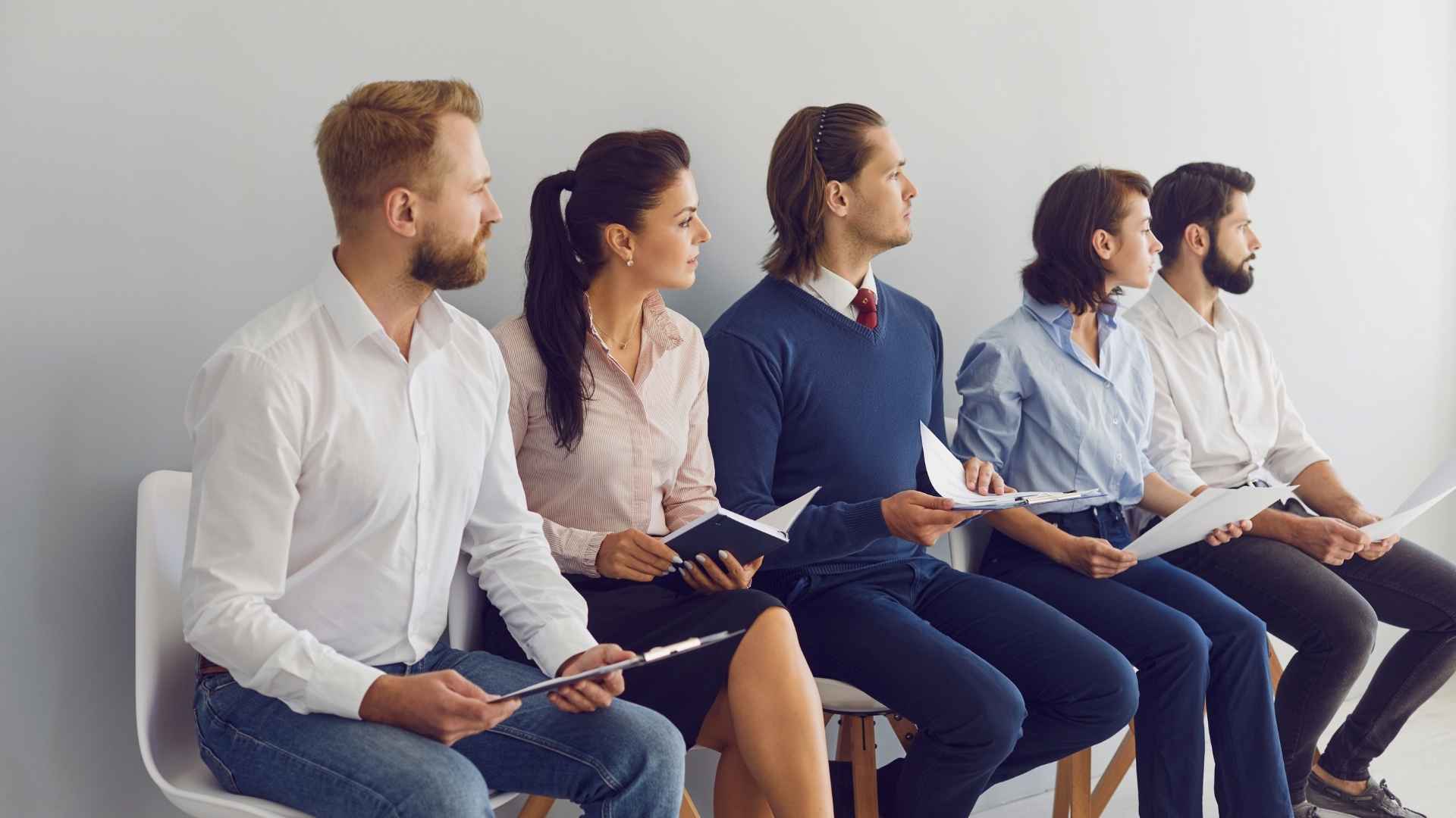 Candidates waiting with resumes before an interview